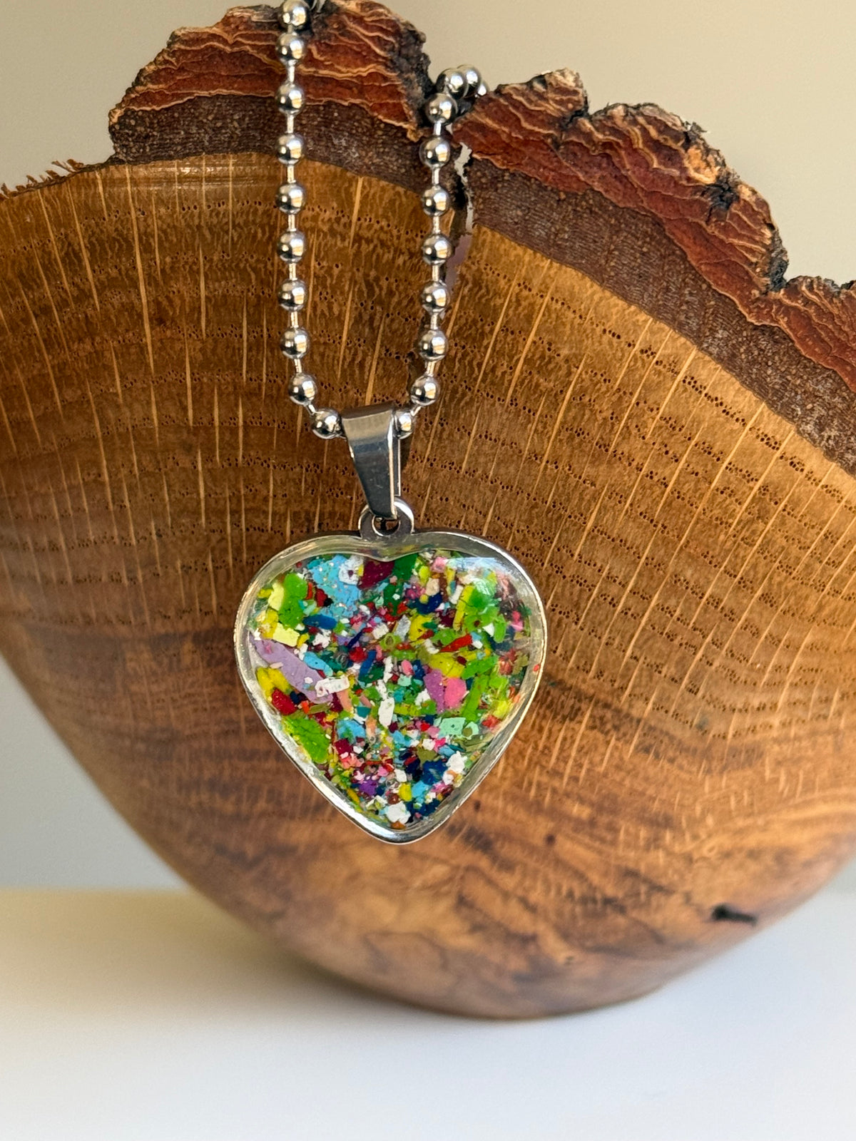 Multicolor crayon filled heart shaped stainless steel pendant. Crayon jewelry by Crayonfetti, mother-daughter based in Atlanta.
