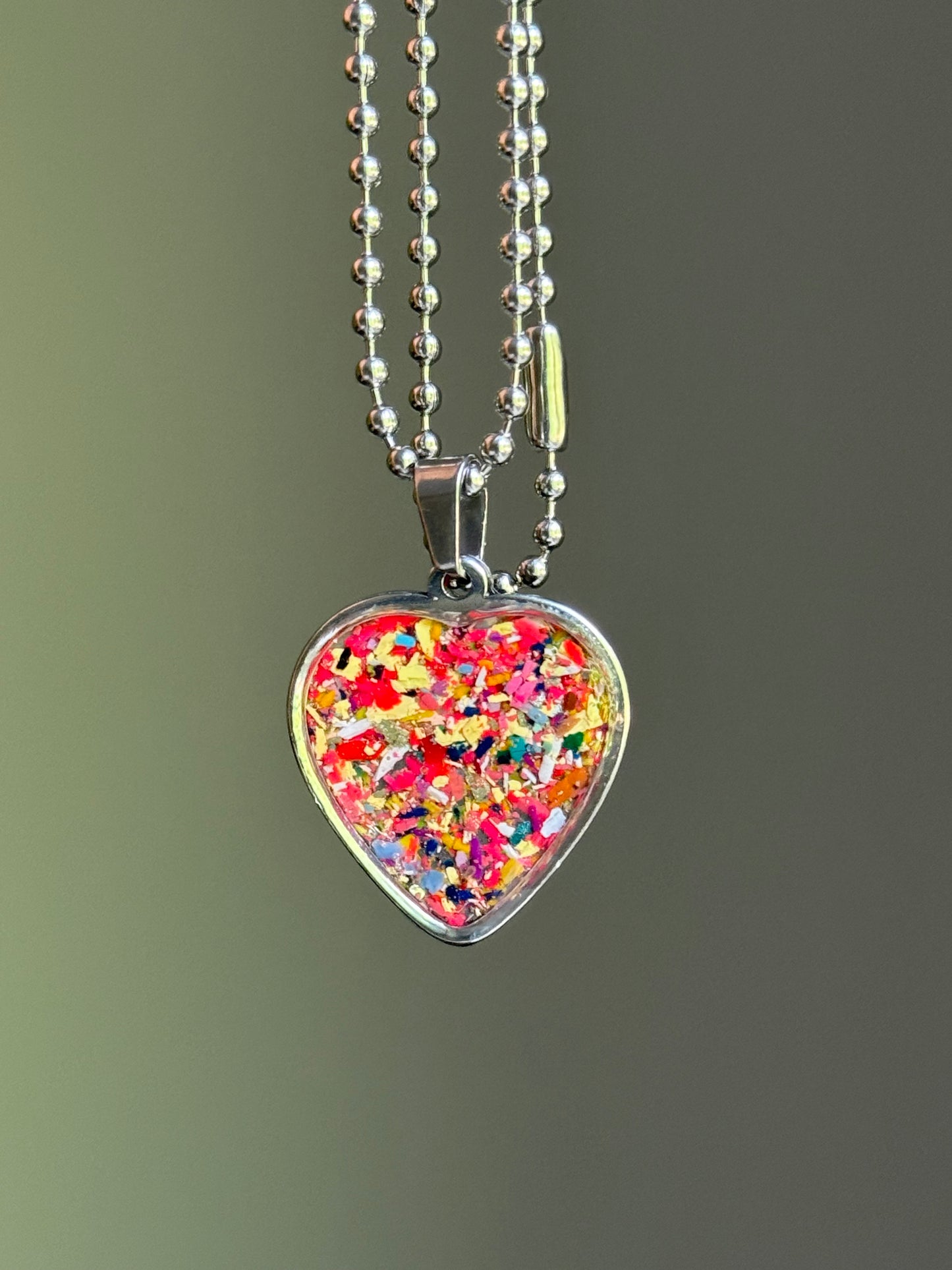 Detail view of the durable hypoallergenic stainless steel bail on the Solar Spark crayon heart pendant.
