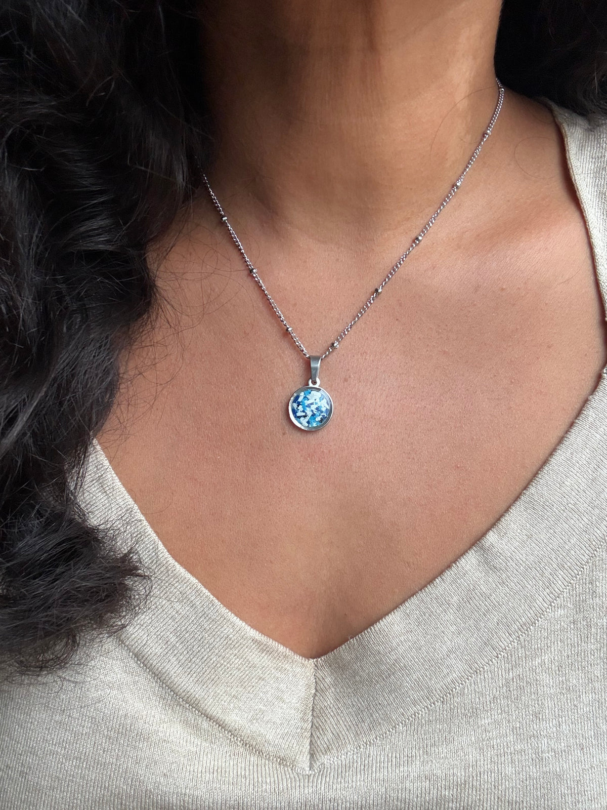 Blue and white round stainless steel pendant filled with crayon shavings. Dainty necklace. Crayonfetti crayon jewelry by mother-daughter based in Atlanta, Georgia.