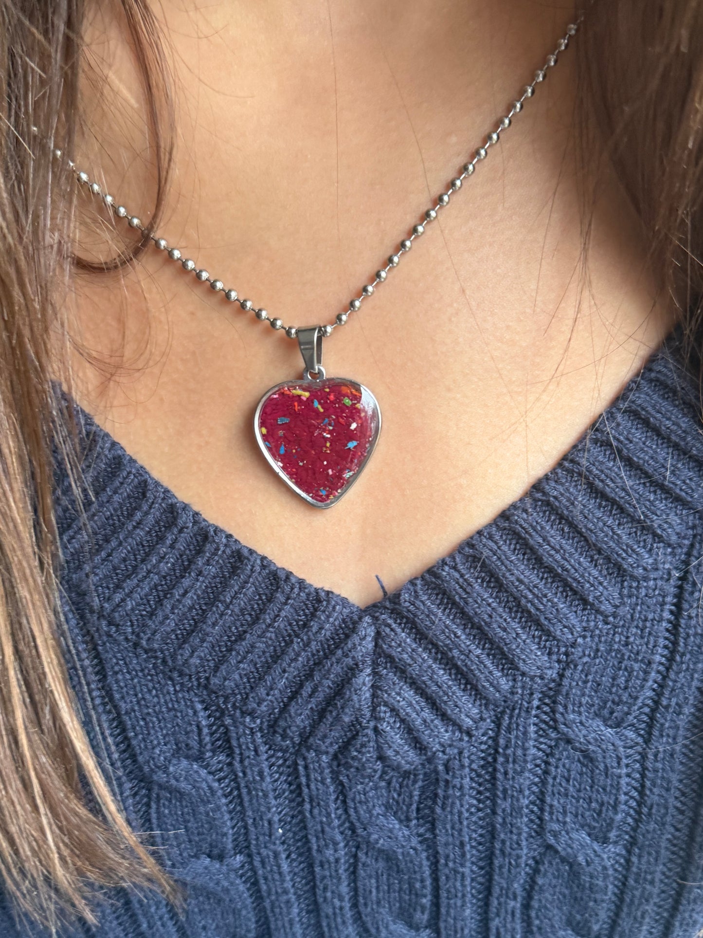 Red-violet crayon filled heart shaped stainless steel pendant. Crayon jewelry by Crayonfetti, mother-daughter based in Atlanta.