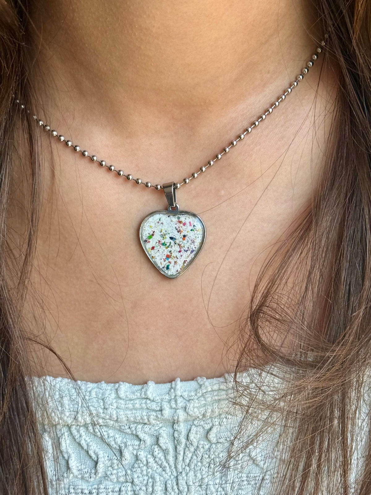 White freckled crayon filled heart shaped stainless steel pendant. Crayon jewelry by mother-daughter based in Atlanta, GA.