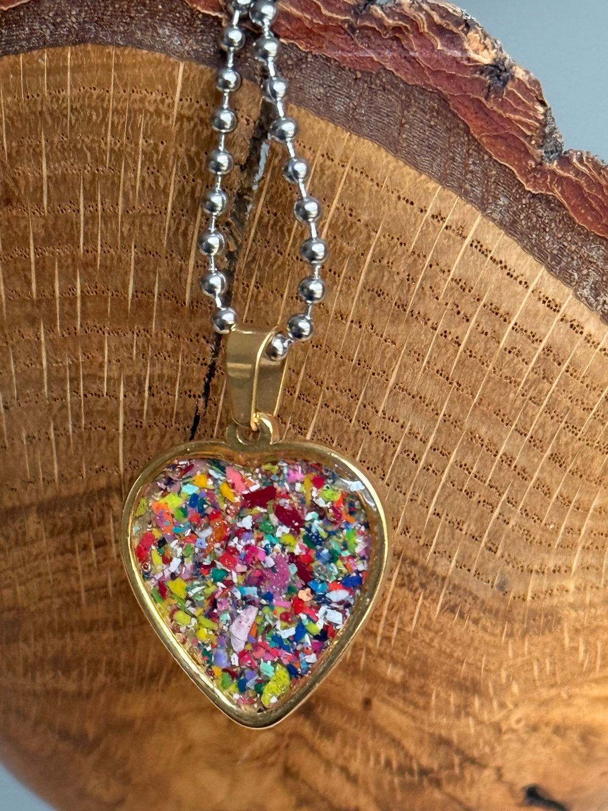Red-violet crayon filled heart shaped stainless steel pendant. Crayon jewelry by Crayonfetti, mother-daughter based in Atlanta.