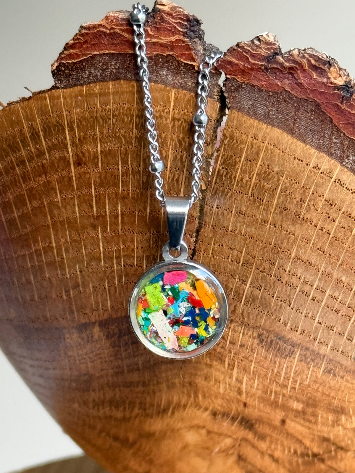 Multicolor round stainless steel pendant filled with crayon shavings. Dainty necklace. Crayonfetti crayon jewelry by mother-daughter based in Atlanta, Georgia.
