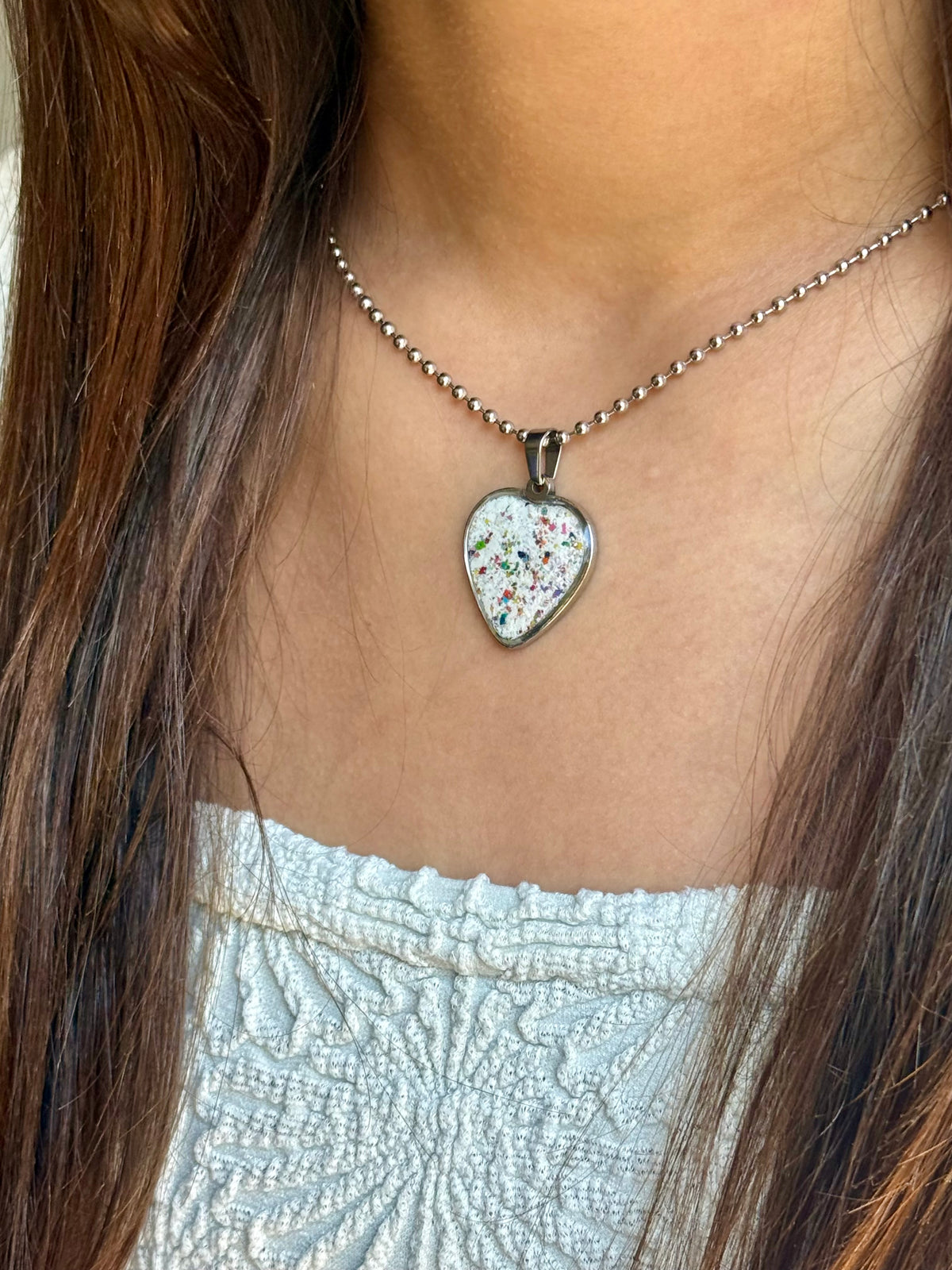 White freckled crayon filled heart shaped stainless steel pendant. Crayon jewelry by mother-daughter based in Atlanta, GA.