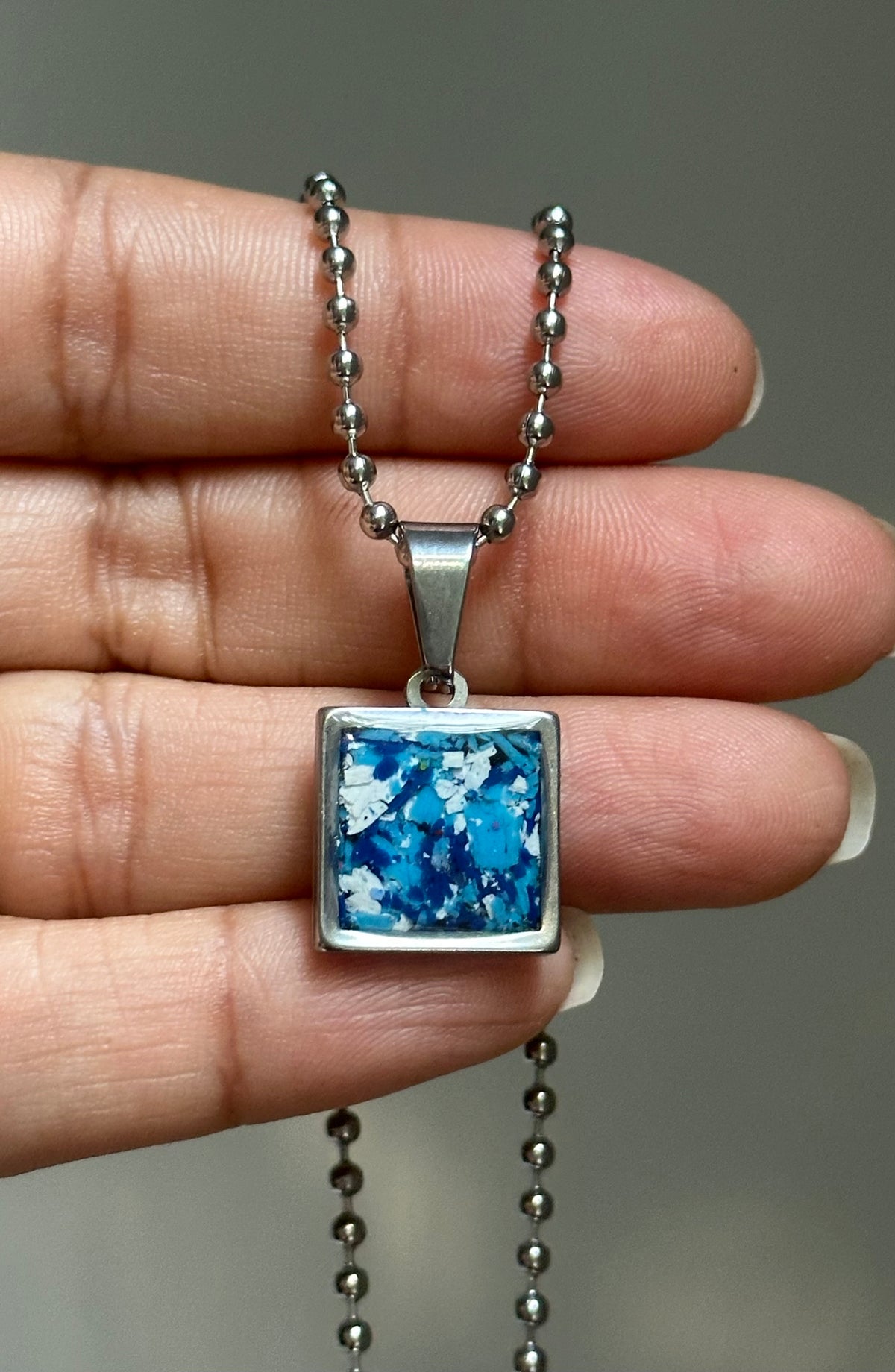 blue and white small square stainless steel pendant filled with crayon shavings. Dainty necklace. Crayonfetti crayon jewelry by mother-daughter based in Atlanta, Georgia.