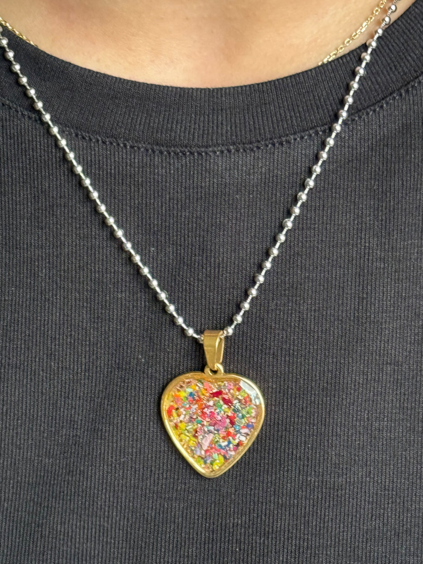 Multicolor crayon filled heart shaped stainless steel pendant. Crayon jewelry by Crayonfetti, mother-daughter based in Atlanta.
