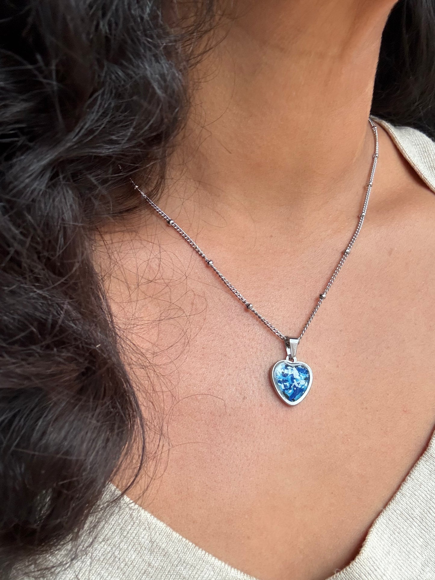 Blue and white small heart stainless steel pendant filled with crayon shavings. Dainty necklace. Crayonfetti crayon jewelry by mother-daughter based in Atlanta, Georgia.