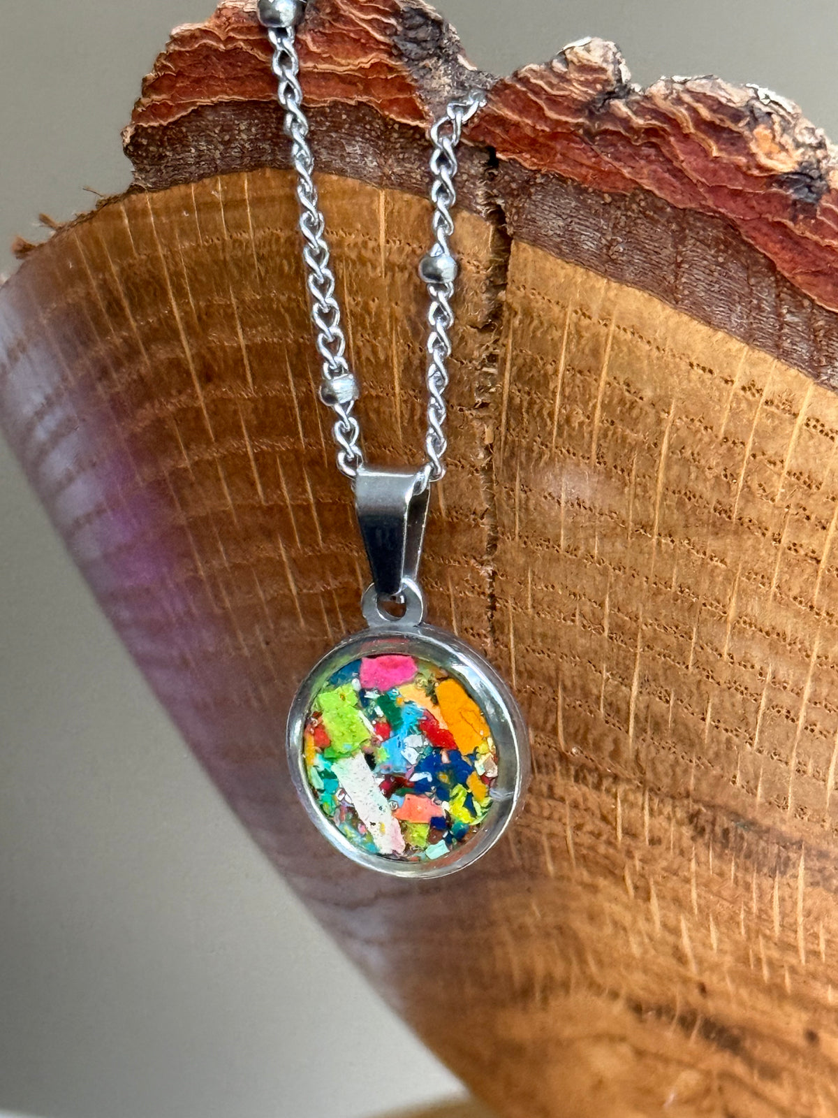 Multicolor round stainless steel pendant filled with crayon shavings. Dainty necklace. Crayonfetti crayon jewelry by mother-daughter based in Atlanta, Georgia.