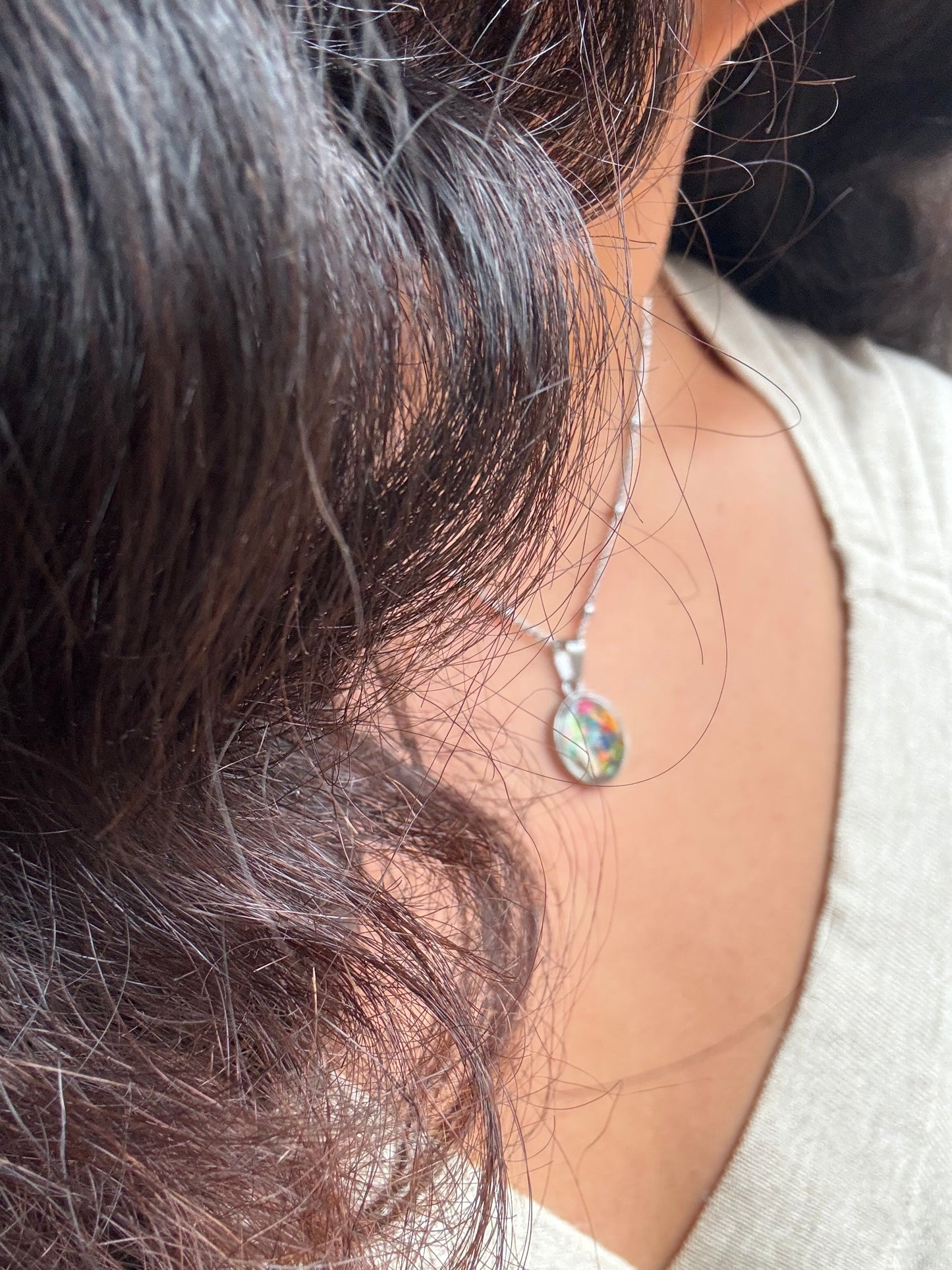 Multicolor round stainless steel pendant filled with crayon shavings. Dainty necklace. Crayonfetti crayon jewelry by mother-daughter based in Atlanta, Georgia.