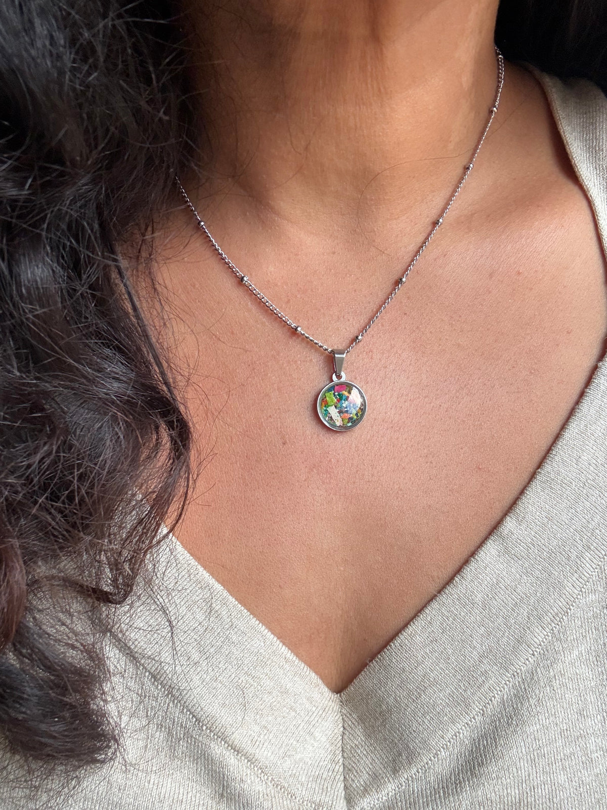 Multicolor round stainless steel pendant filled with crayon shavings. Dainty necklace. Crayonfetti crayon jewelry by mother-daughter based in Atlanta, Georgia.