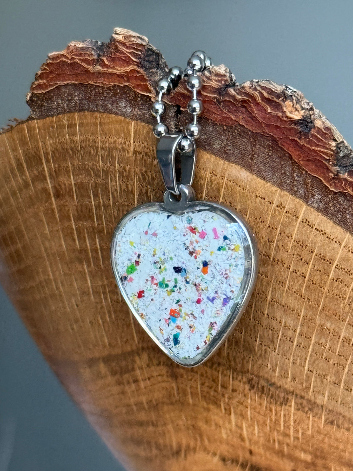White freckled crayon filled heart shaped stainless steel pendant. Crayon jewelry by mother-daughter based in Atlanta, GA.