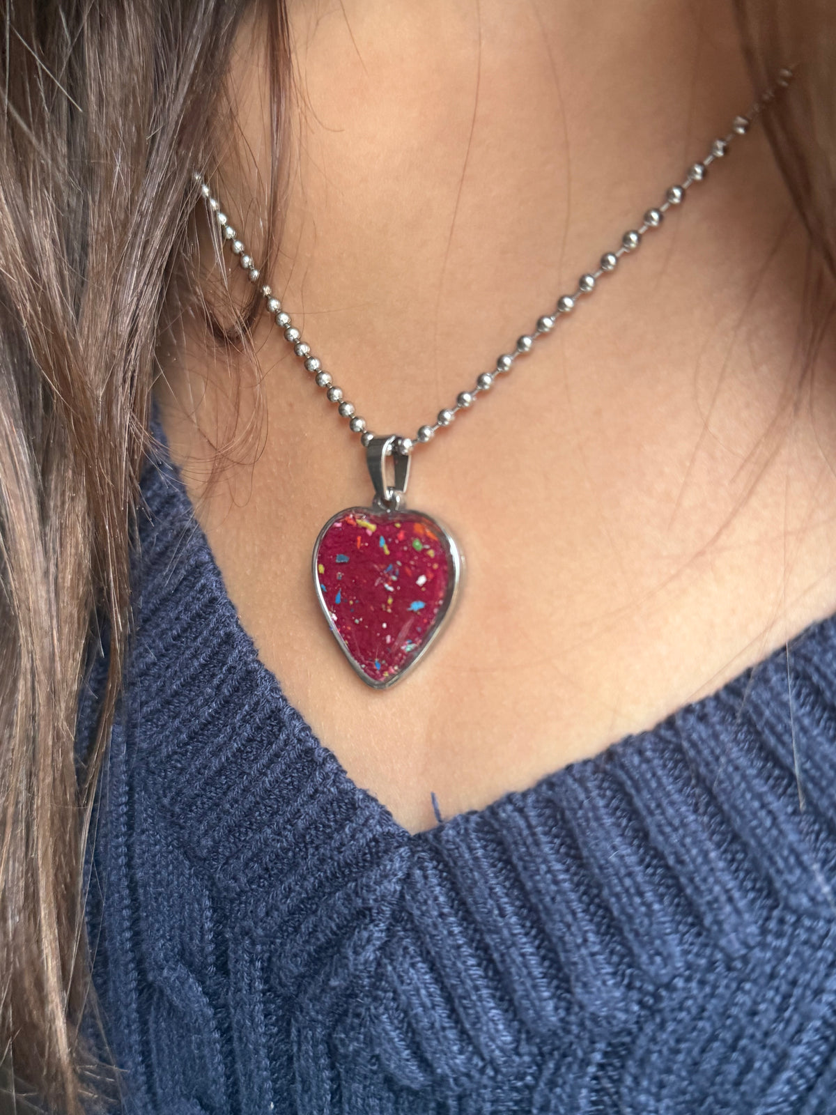 Red-violet crayon filled heart shaped stainless steel pendant. Crayon jewelry by Crayonfetti, mother-daughter based in Atlanta.