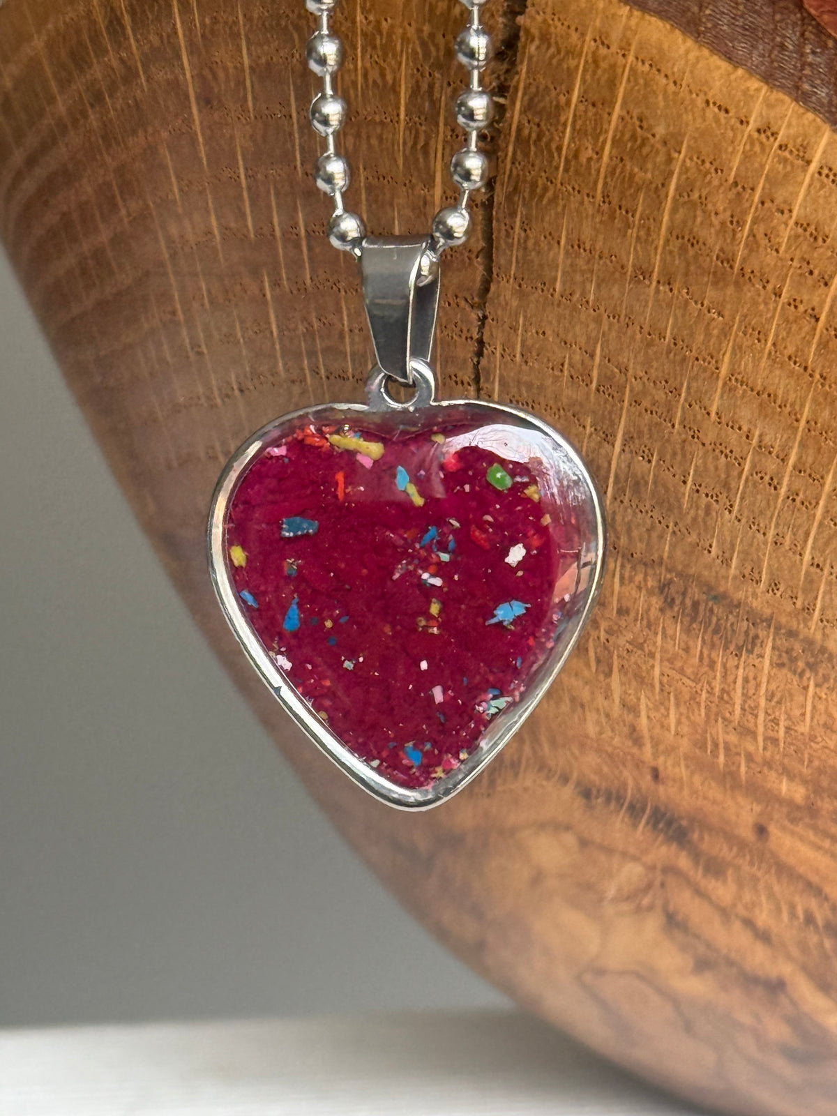 Red-violet crayon filled heart shaped stainless steel pendant. Crayon jewelry by Crayonfetti, mother-daughter based in Atlanta.