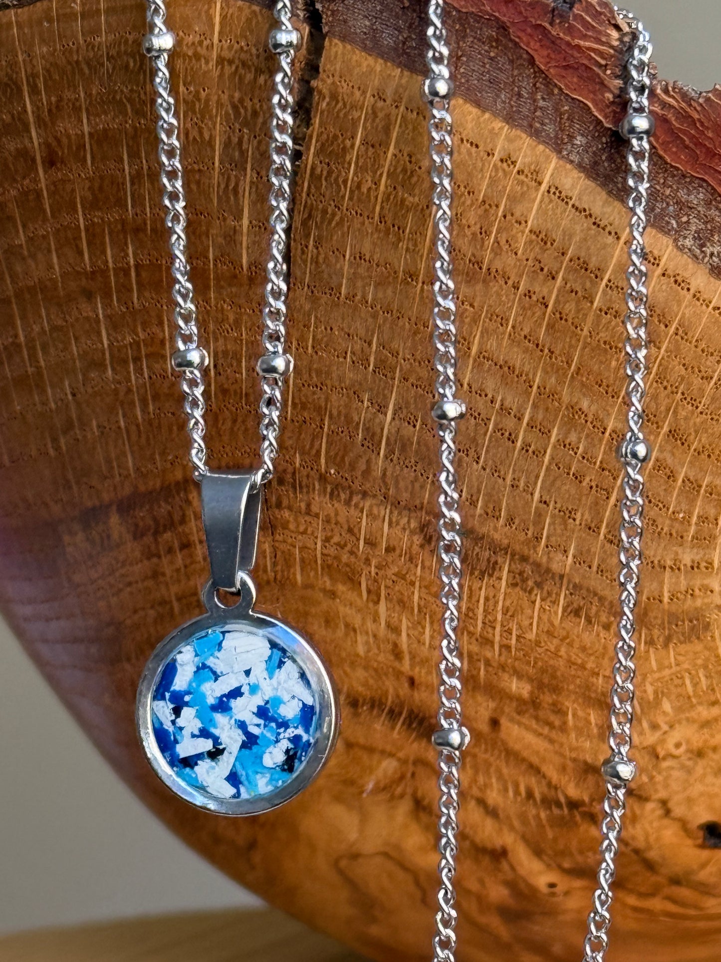 Blue and white round stainless steel pendant filled with crayon shavings. Dainty necklace. Crayonfetti crayon jewelry by mother-daughter based in Atlanta, Georgia.