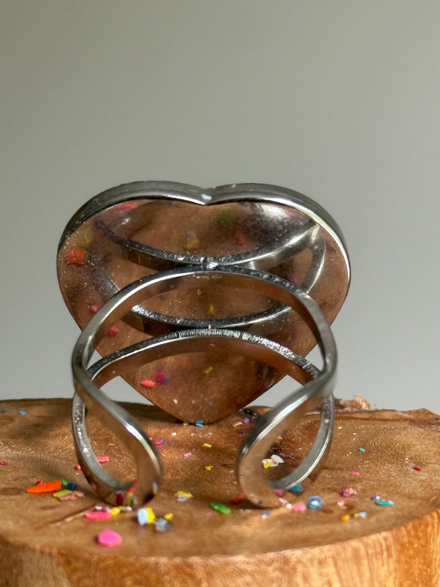 Overhead view of blue crayon jewelry featuring a quarter-size heart-shaped crayon ring band.