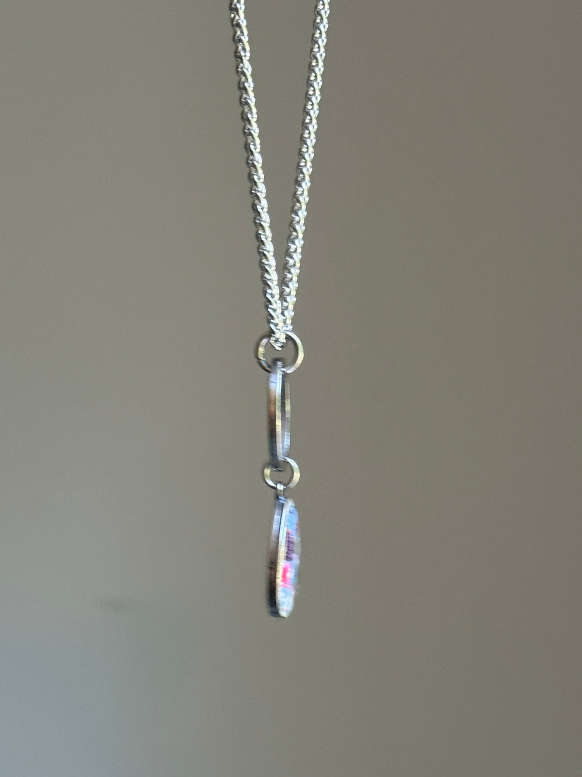 Full view of the periwinkle purple crayon pendant necklace hanging in mid-air to show chain length and drop.