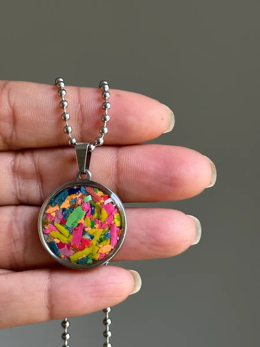 Stainless steel round pendant filled with crayon shavings by crayonfetti. Crayon jewelry. Crayon gifts. Teacher gift idea. Crayonpendants. Crayon pendants.