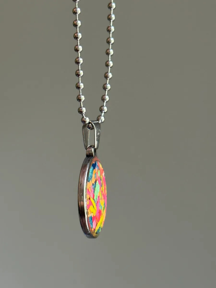Stainless steel round pendant filled with crayon shavings by crayonfetti. Crayon jewelry. Crayon gifts. Teacher gift idea. Crayonpendants. Crayon pendants.
