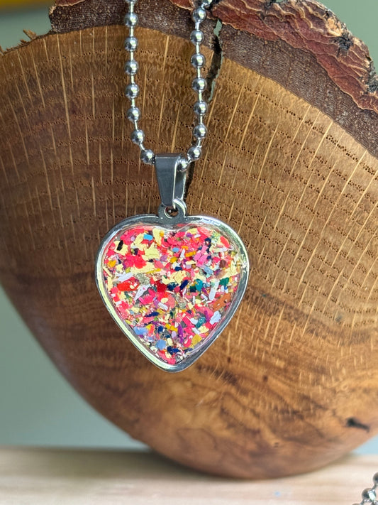 Front view of the Solar Spark heart-shaped pendant showcasing the vibrant upcycled crayon colors