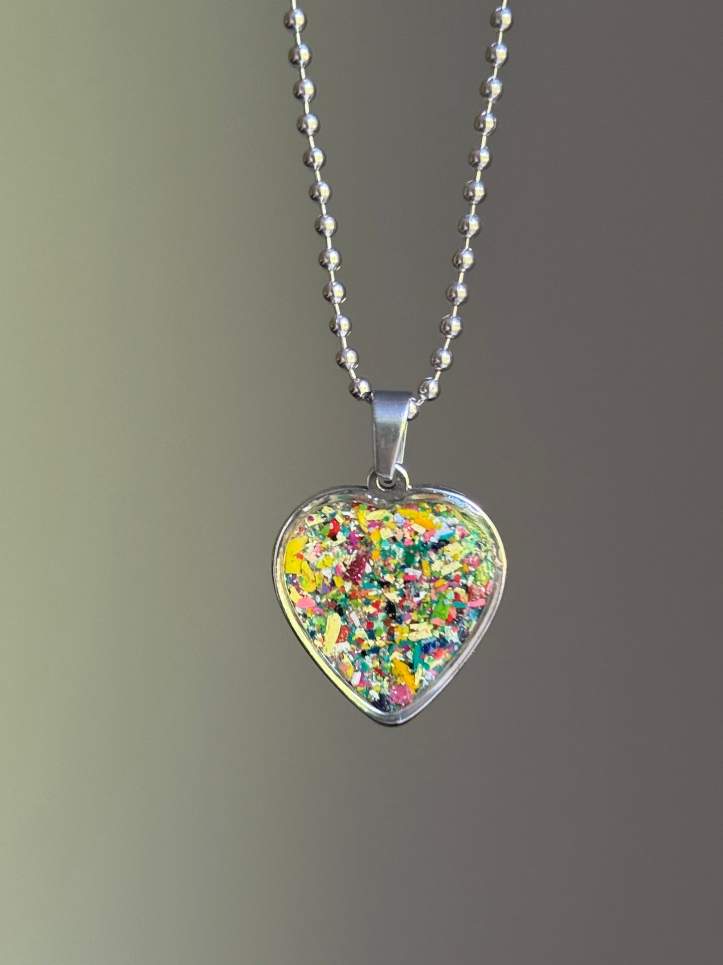 dark-toned crayon shavings heart pendant colorful upcycled necklace. Crayon jewelry by Crayonfetti, mother-daughter based in Atlanta.