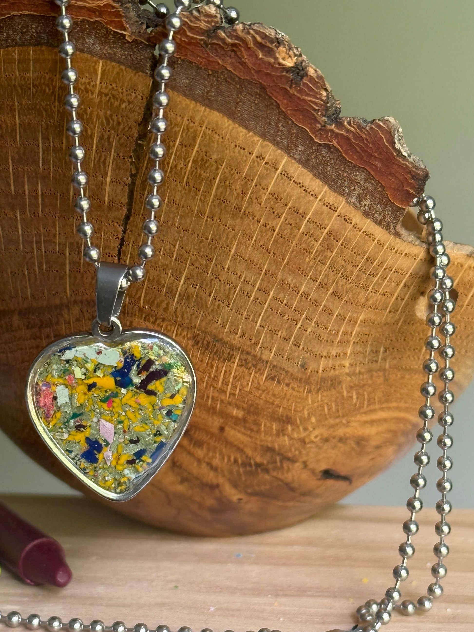 mixed yellow crayon shavings heart necklace worn as styled statement jewelry. Crayon jewelry by Crayonfetti, mother-daughter based in Atlanta.