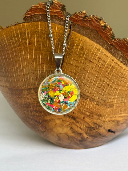 Round pendant necklace filled with crayons. Crayon Jewelry