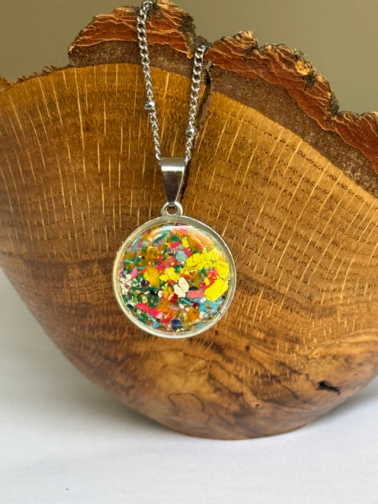 Round pendant necklace filled with crayons. Crayon Jewelry