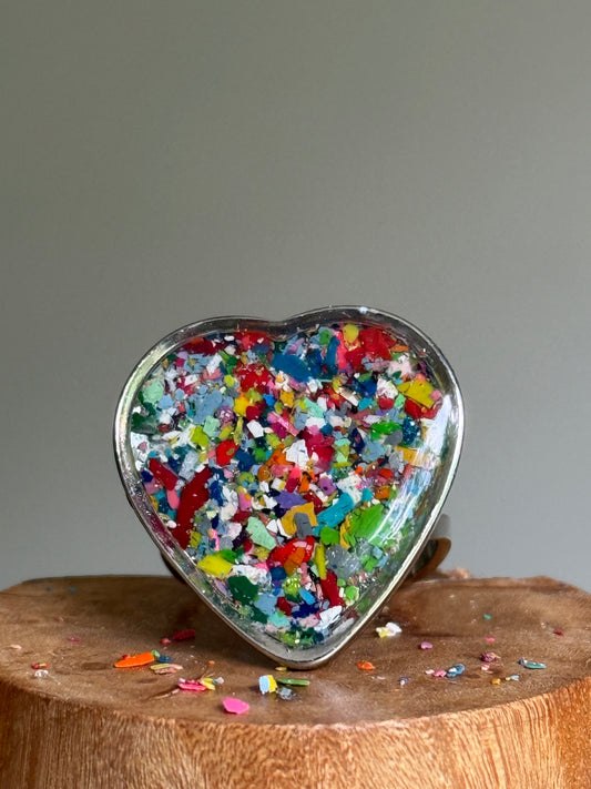 Close-up of green crayon jewelry showing a quarter-size heart crayon ring set in durable stainless steel.