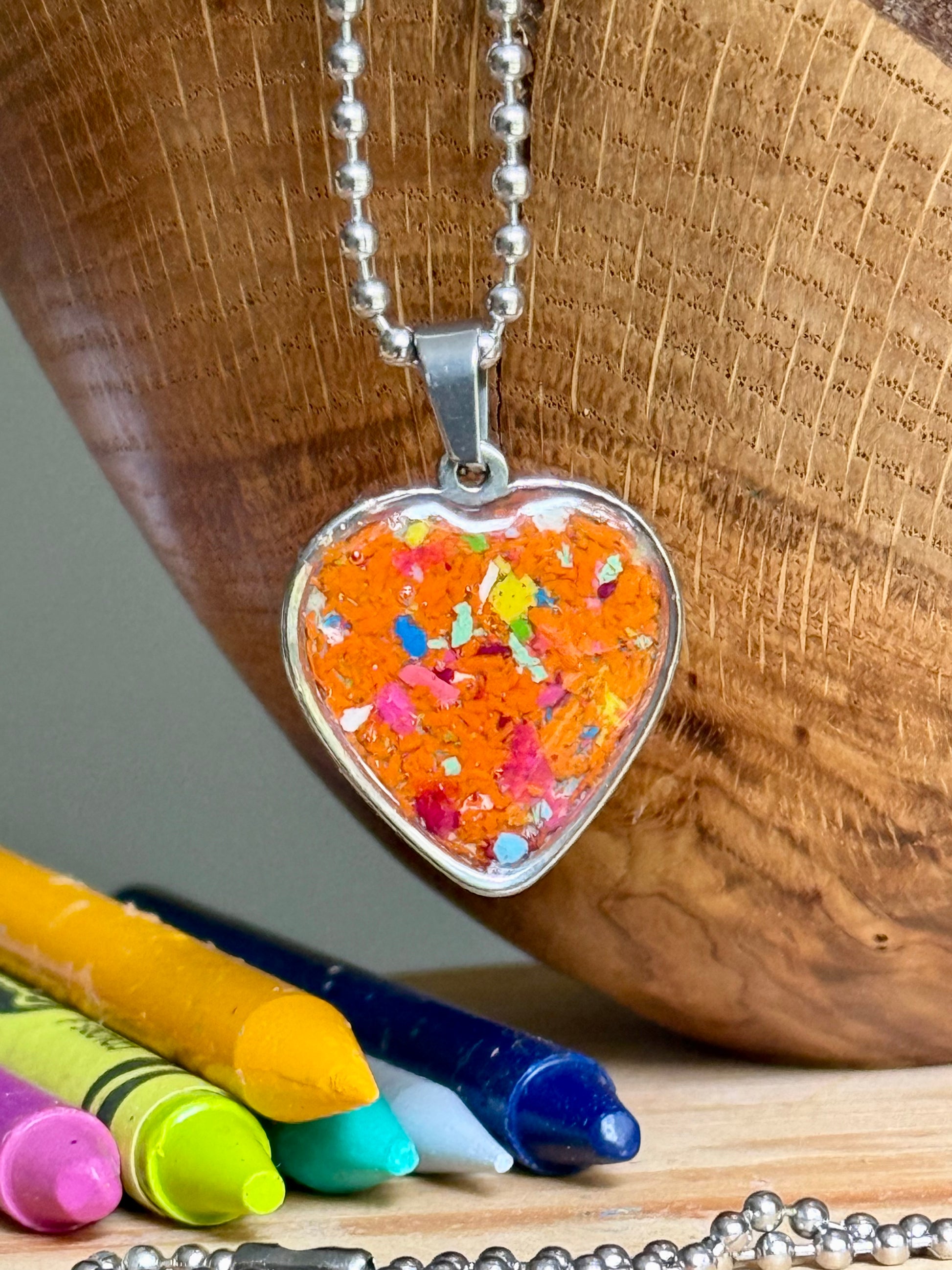 Bright orange crayon heart necklace worn as everyday jewelry, perfect as a colorful handmade gift.