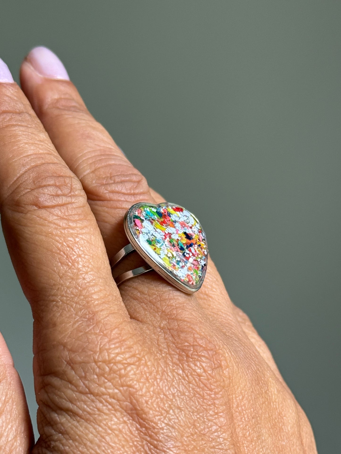 Stainless steel crayon ring with a vibrant blue and multicolored upcycled crayon heart bezel.