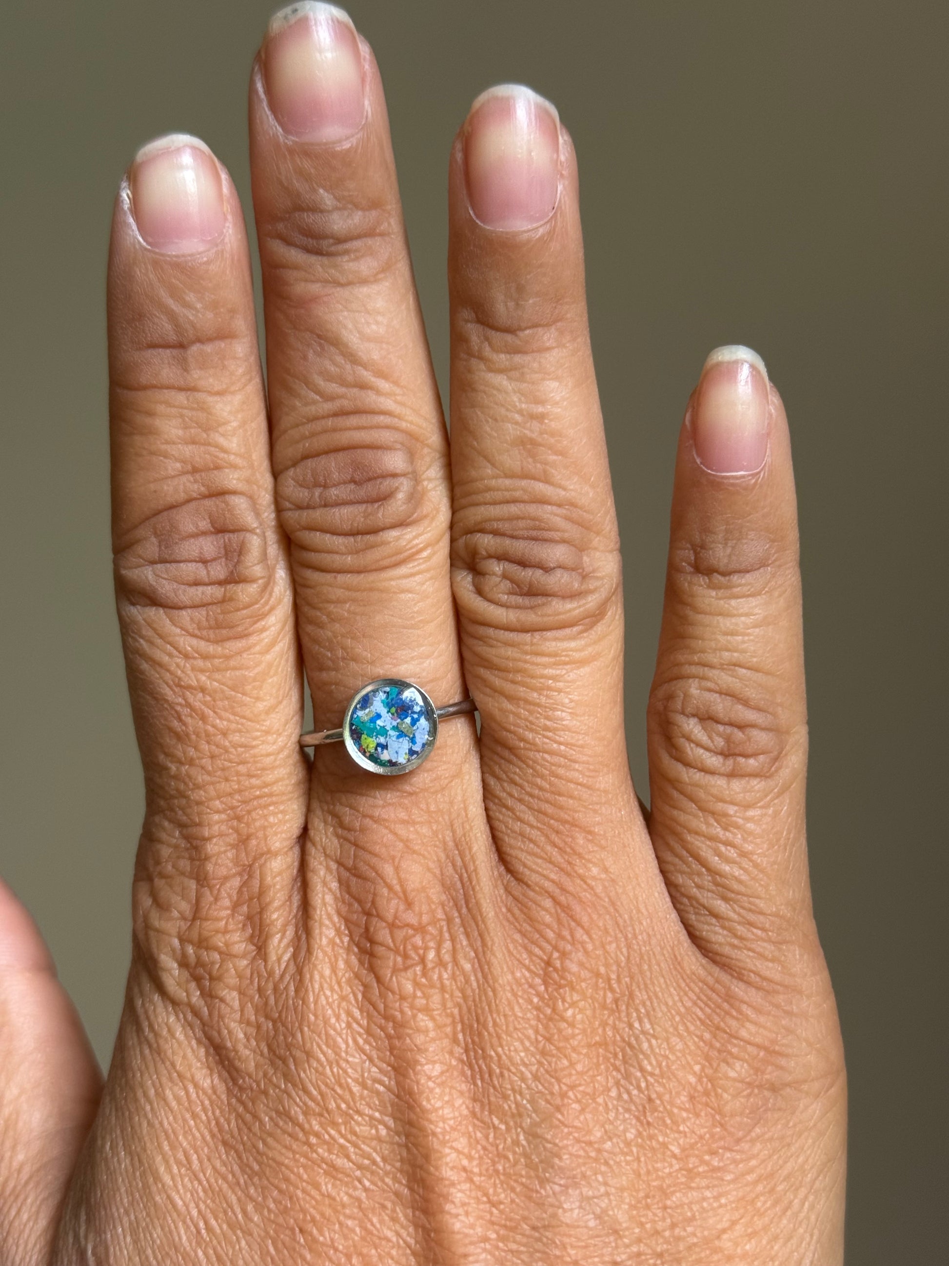 A hand showcasing the rich navy details of the Midnight Sparkler stainless steel ring, featuring authentic crayon jewelry by Crayonfetti.