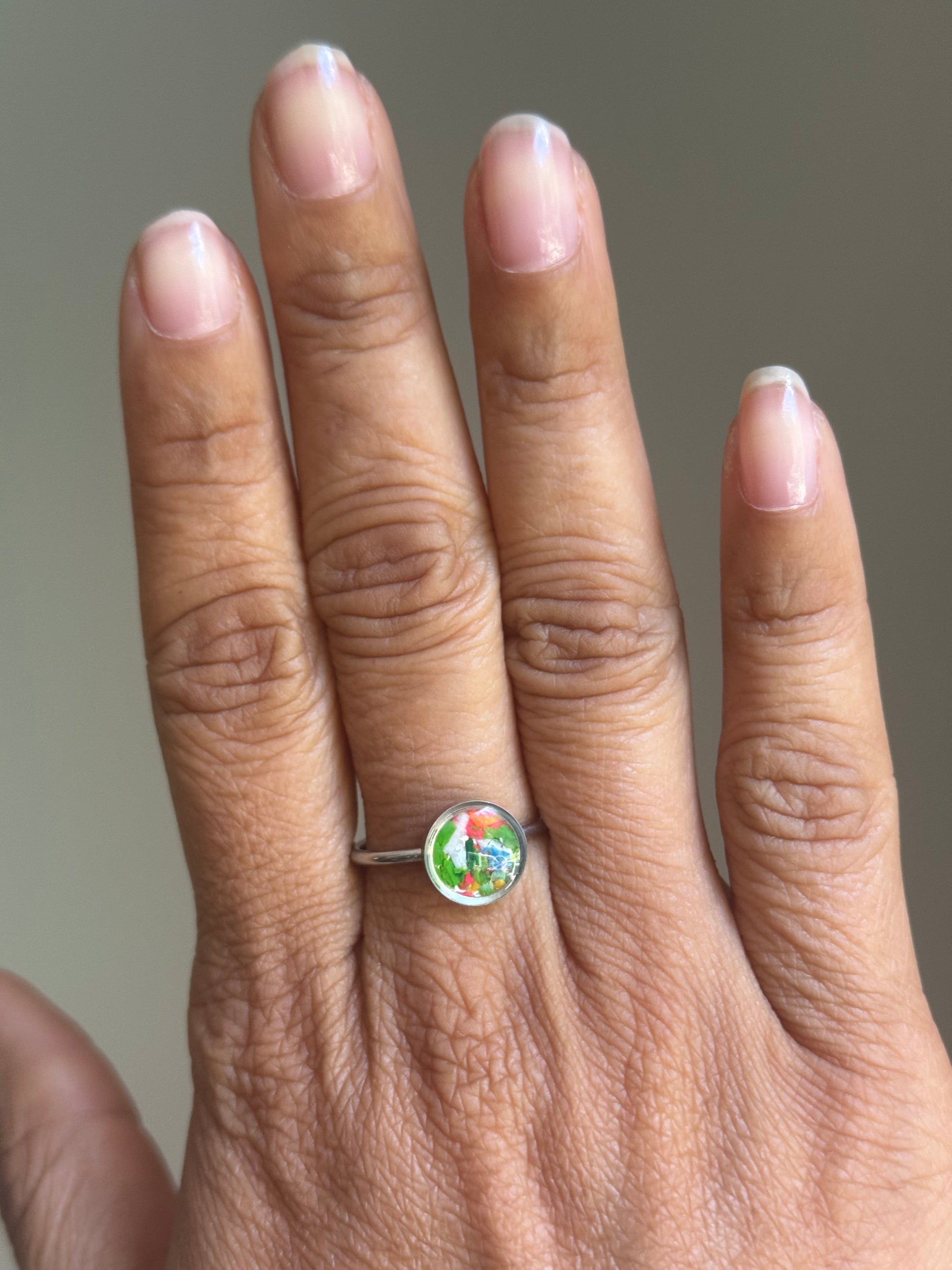 A hand showcasing the radiant, neon orange details of the Sunkist stainless steel ring, featuring authentic crayon jewelry by Crayonfetti.
