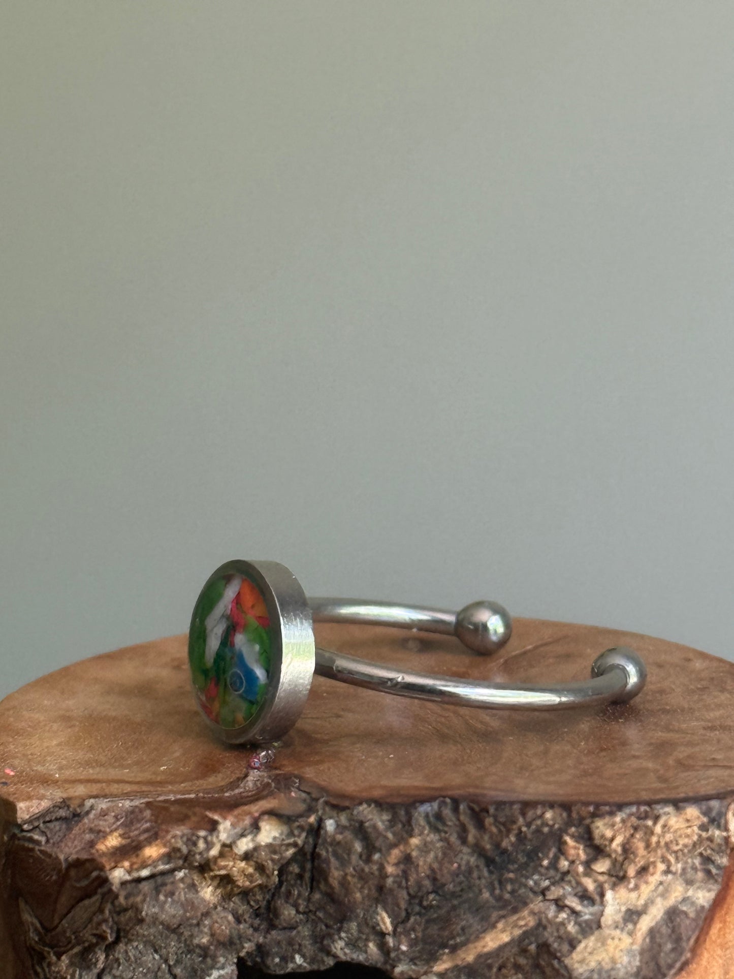 A delicate stainless steel ring filled with a cheerful, sun-kissed blend of recycled orange crayon shavings, handmade by Crayonfetti.