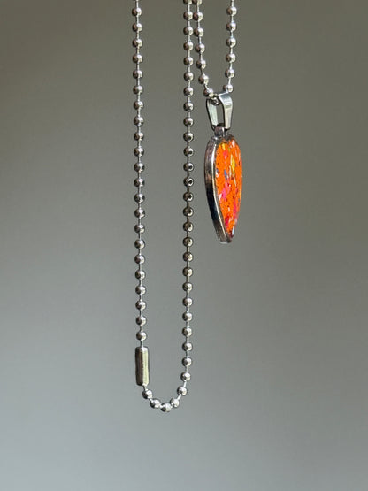 Side angle of a handcrafted heart pendant made with reclaimed crayons and hypoallergenic stainless steel. By Crayonfetti
