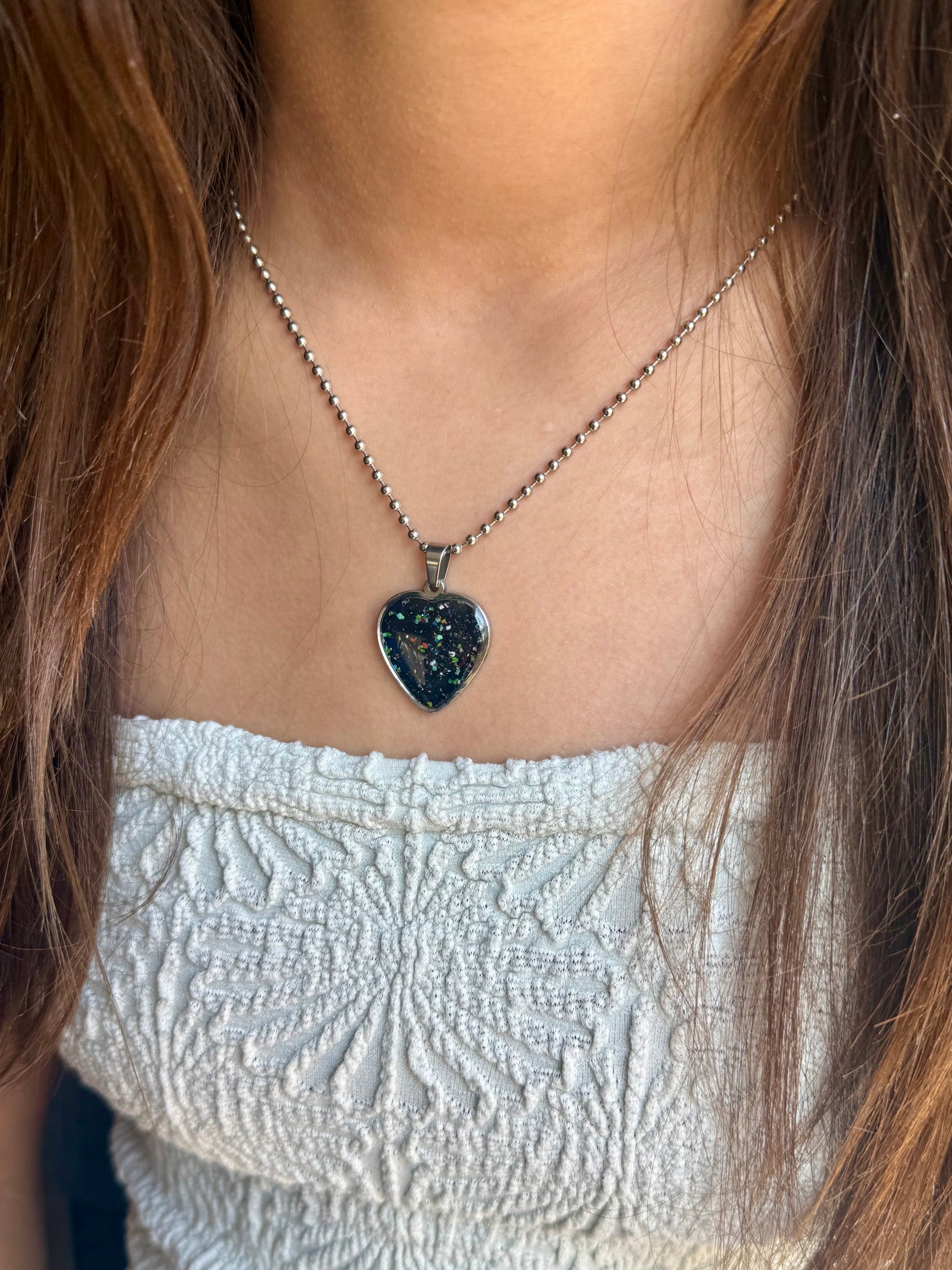 one-of-a-kind black heart pendant made from reclaimed crayon shavings with colorful sprinkle details, handcrafted crayon jewelry.