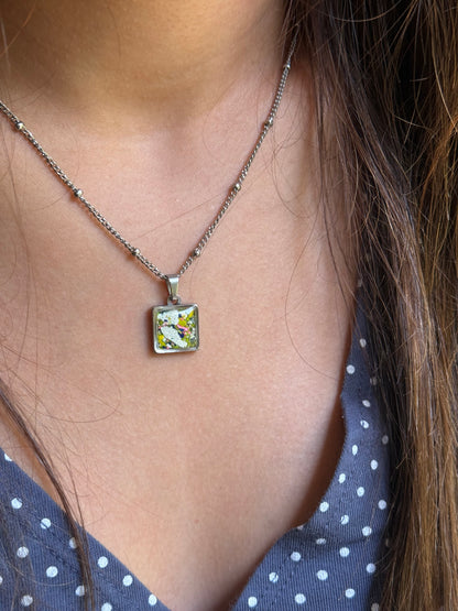 Crayonfetti square pendant made from recycled crayon shavings, unique crayon jewelry with metallic white, navy, and yellow colors, crayon jewelry.