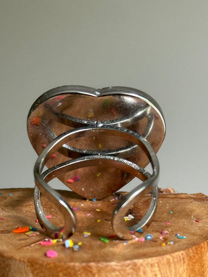 Overhead view of blue crayon jewelry featuring a quarter-size heart-shaped crayon ring band.