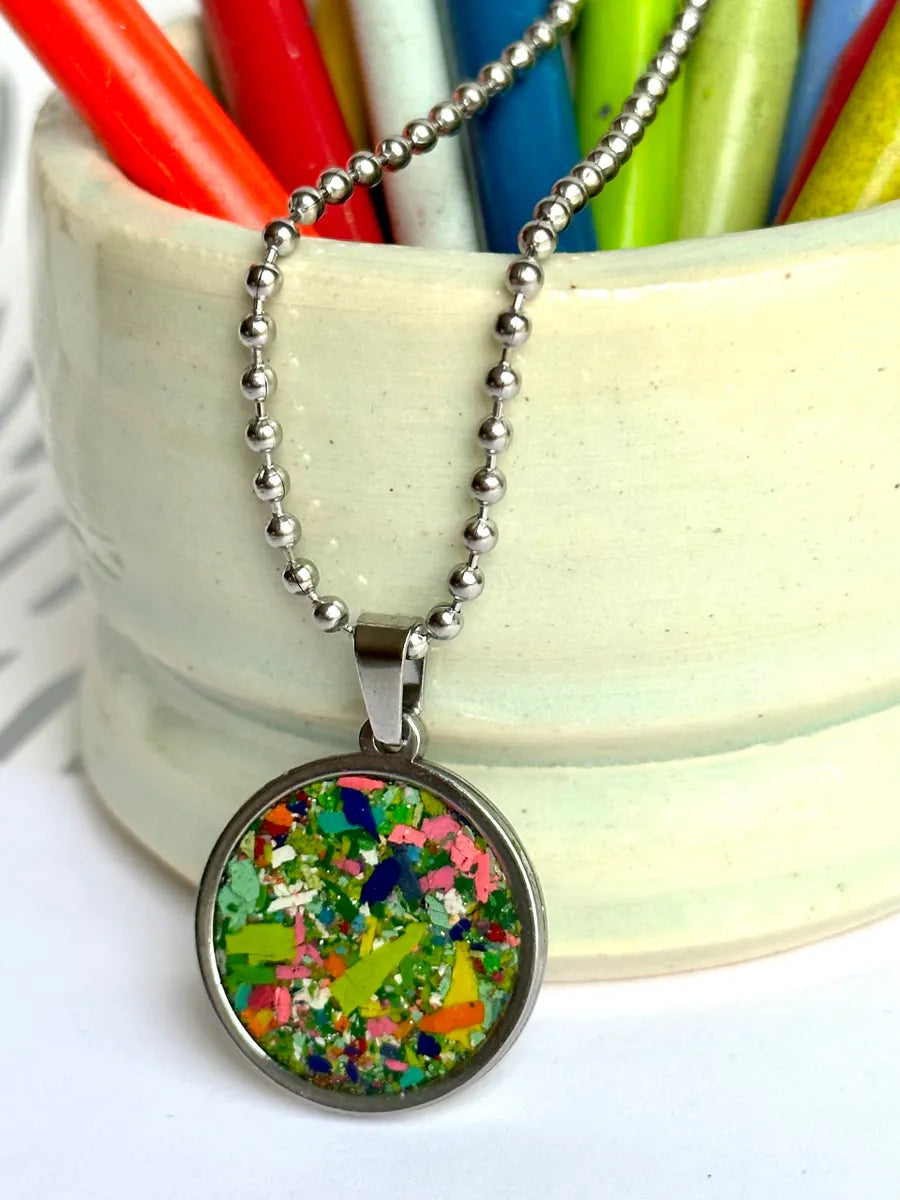 Stainless steel round pendant filled with crayon shavings by crayonfetti. Crayon jewelry.  Crayon gifts. Teacher gift idea.  Crayonpendants.  Crayon pendants.