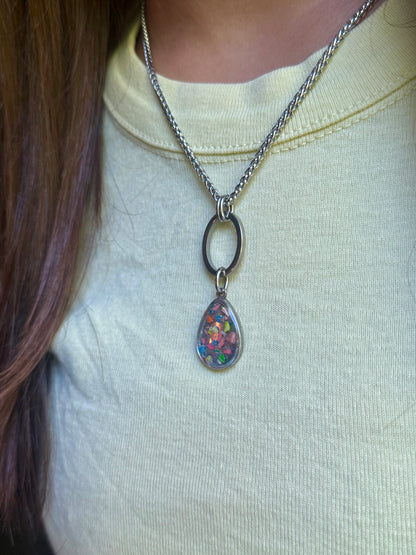 Close-up of model in a yellow top showcasing the stainless steel  geometric open link resin crayon necklace.